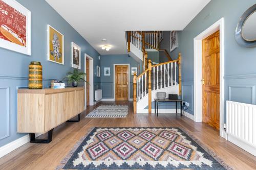 CarneatlyにあるRamoan Houseの青い壁の廊下、敷物のある階段
