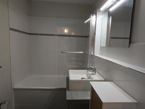 une salle de bain blanche avec un lavabo et une baignoire dans l'établissement 3 pièces + coin montagne, 2*, 8 pers, proche pistes et commerces, parking, animaux OK - FR-1-445-16, à Montgenèvre