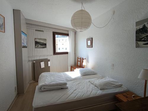 - une chambre avec un lit et une lampe pendant dans l'établissement 3 pièces + coin montagne, 2*, 8 pers, proche pistes et commerces, parking, animaux OK - FR-1-445-16, à Montgenèvre