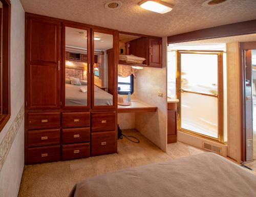 a bedroom with a bed and a desk with a window at ATHENS MOTORHOME park RV WINNEBAGO in Pallíni