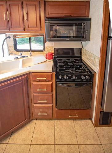 an rv kitchen with a stove and a microwave at ATHENS MOTORHOME park RV WINNEBAGO in Pallíni