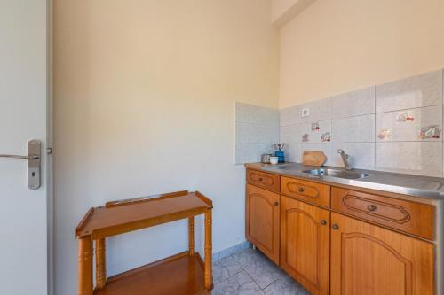 a kitchen with a sink and a wooden cabinet at Alex bar apartments in Sarakiniko