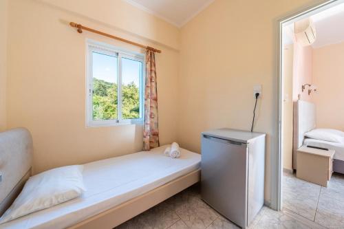 a small bedroom with a bed and a window at Alex bar apartments in Sarakiniko