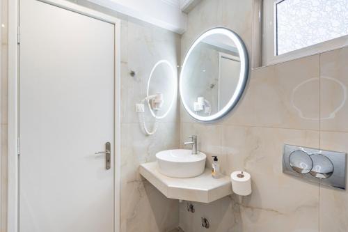 a bathroom with a sink and a mirror at Alex bar apartments in Sarakiniko