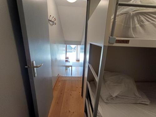Cette petite chambre dispose de lits superposés et d'un couloir. dans l'établissement Superbe appartement rénové - 4 pers - Terrasse plein sud - Garage privé - Proche pistes et commodités - FR-1-445-46, à Montgenèvre