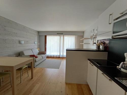 une cuisine et un salon avec une table et un canapé dans l'établissement Superbe appartement rénové - 4 pers - Terrasse plein sud - Garage privé - Proche pistes et commodités - FR-1-445-46, à Montgenèvre
