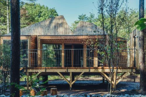 a tree house with a deck in the woods at SANU 2nd Home 八ヶ岳 3rd in Nagasawa