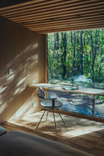 a room with a desk and a chair in front of a window at SANU 2nd Home 八ヶ岳 3rd in Nagasawa