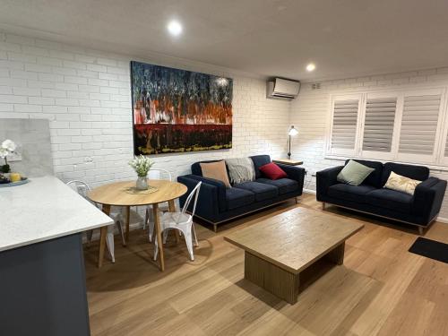 a living room with two couches and a table at Central Cullen Wagga Apartments in Wagga Wagga