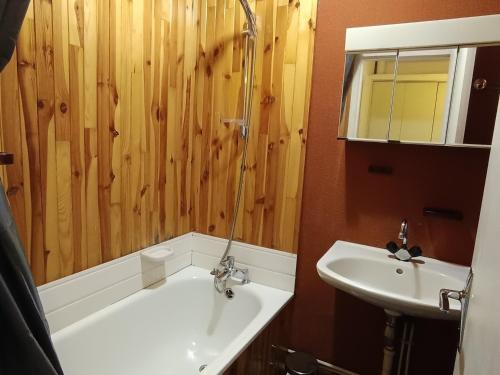 une salle de bain avec une baignoire et un lavabo dans l'établissement Studio exposé sud avec balcon, à 200m des pistes et commerces, animaux acceptés - FR-1-445-26, à Montgenèvre