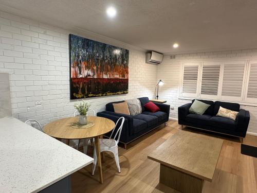 a living room with a couch and a table at Central Cullen Wagga Apartments in Wagga Wagga