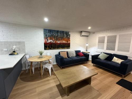 a living room with a couch and a table at Central Cullen Wagga Apartments in Wagga Wagga