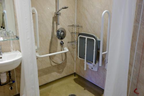 a shower in a bathroom with a sink and a shower at Glen Mhor Hotel at Uile-bheist 'Brewstillery' in Inverness