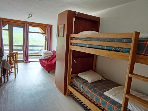 une chambre avec deux lits superposés et une salle à manger dans l'établissement Studio exposé sud avec balcon, à 200m des pistes et commerces, animaux acceptés - FR-1-445-26, à Montgenèvre