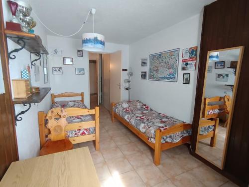 une petite chambre avec deux lits et une table dans l'établissement Bel Appartement 6p, 2 étoiles, Près des pistes avec Balcon - Montgenèvre Village - FR-1-445-183, à Montgenèvre