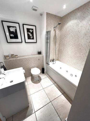 a bathroom with a tub and a toilet and a sink at Seaview Hideway - Abnb in Portstewart