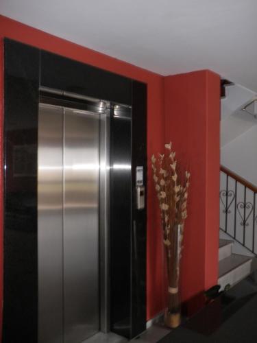a stainless steel refrigerator in a room with a red wall at Morning Star in Kambos