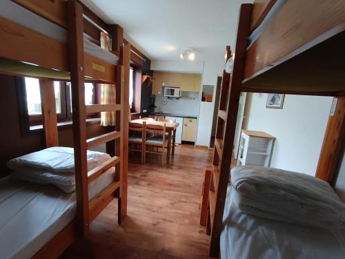 une chambre avec des lits superposés et une salle à manger dans l'établissement Studio économique 4 pers - 1* - Animaux admis - Centre village Montgenèvre - FR-1-445-75, à Montgenèvre