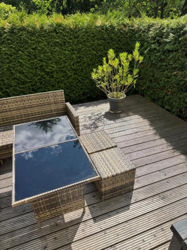 a patio with a glass table and wicker chairs at Ferienhaus Schülke in Buckow