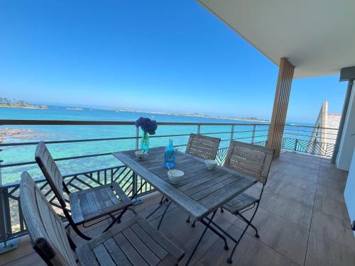 a table on a balcony with a view of the ocean at Soleil couchant in Roscoff