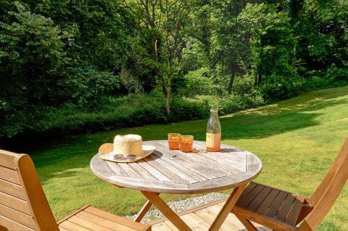 a picnic table with a bottle of wine and glasses at FORET TOTEM - Hébergements nature et bien-être en pleine forêt in Persquen