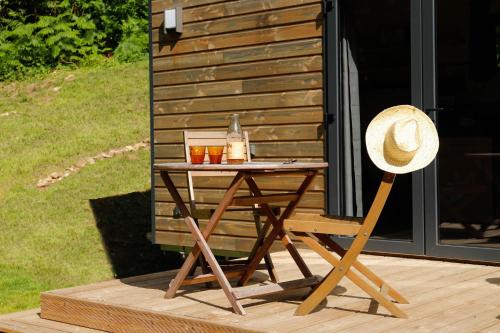 a straw hat sitting on a table next to a cabin at FORET TOTEM - Hébergements nature et bien-être en pleine forêt in Persquen