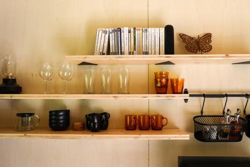 a shelf with glasses and other items on it at FORET TOTEM - Hébergements nature et bien-être en pleine forêt in Persquen