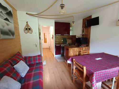 un salon avec une table et un canapé dans l'établissement Appartement rénové avec Wifi, plein sud, sur les pistes, parking privé – 4 à 5 pers. - FR-1-445-157, à Montgenèvre