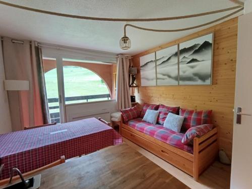 - une chambre avec un canapé et un lit dans l'établissement Appartement rénové avec Wifi, plein sud, sur les pistes, parking privé – 4 à 5 pers. - FR-1-445-157, à Montgenèvre