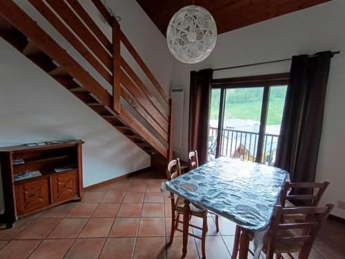 une salle à manger avec une table et un escalier dans l'établissement Duplex 3* pour 4 pers - Centre village, à 100m des pistes - Confort et charme - FR-1-445-129, à Montgenèvre