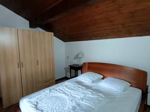 une chambre avec un lit et une tête de lit en bois dans l'établissement Duplex 3* pour 4 pers - Centre village, à 100m des pistes - Confort et charme - FR-1-445-129, à Montgenèvre