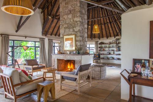 a living room with a fireplace in a villa at Ololo Safari Lodge & Farm in Nairobi