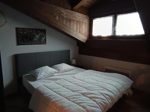 une chambre avec un lit blanc avec une fenêtre dans l'établissement Appartement 5 pièces, 8 pers, balcon, parking, animaux admis - FR-1-445-179, à Montgenèvre