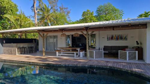 a house with a wooden deck and a swimming pool at Villa Philibert in Riambel