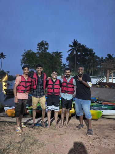 a group of men standing next to a group of boats at The Hostel Stories, Varkala - Helipad Road in Varkala