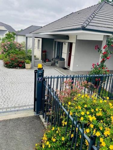 a house with a fence and flowers in front of it at Chez nicolas in Sendets