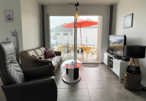 a living room with a couch and a table with an umbrella at Chez nicolas in Sendets