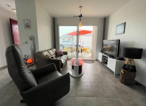 a living room with a couch and chairs and a television at Chez nicolas in Sendets
