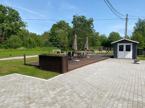 a patio with a table and umbrellas in a park at AUDRU APARTMENT Near Audru Golf and Valgeranna beach in Audru