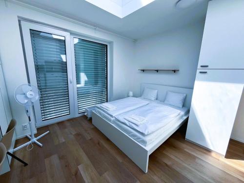 a bedroom with a bed and a large window at Bella Apartments Brno in Brno