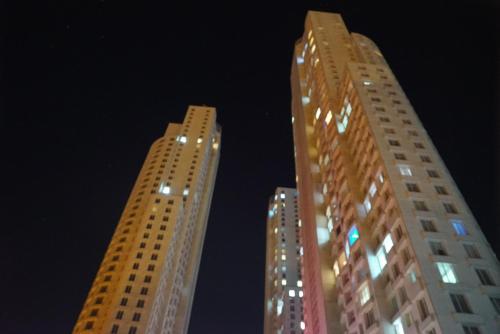 two tall buildings at night with lights on them at Skopje Sky Apartments & Floor 33th 28th & 25th & 19th & 13th 12th With Pool & Spa & Fitness & Parking Included in Price in Skopje