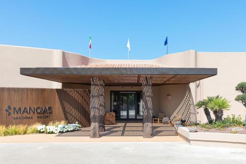 a building with awning on the side of it at Mangia's Sardinia Resort - NEW OPENING in Santa Teresa Gallura