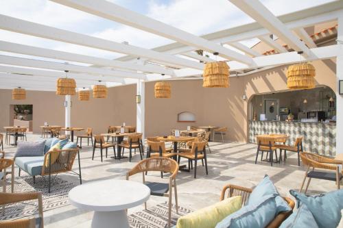 a restaurant with tables and chairs in a room at Mangia's Sardinia Resort - NEW OPENING in Santa Teresa Gallura