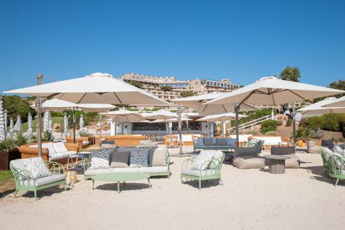 a group of chairs and umbrellas on a beach at Mangia's Sardinia Resort - NEW OPENING in Santa Teresa Gallura