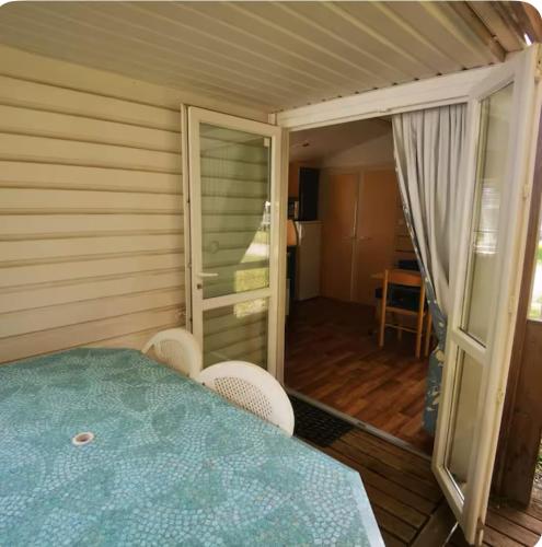 a room with a table and chairs and a balcony at Mobile-Home near to Europa Park, Rulantica in Boofzheim