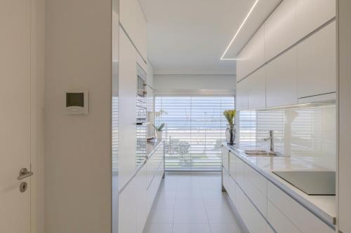 eine Küche mit weißen Arbeitsflächen und weißen Geräten in der Unterkunft SONIA Travels in Matosinhos