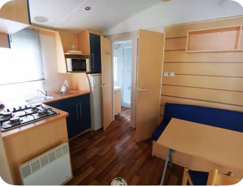 a small kitchen with a table and a stove at Mobile-Home near to Europa Park, Rulantica in Boofzheim