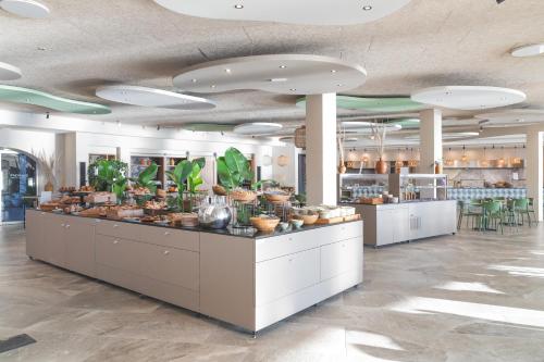 a restaurant with a counter with plants on it at Mangia's Sardinia Resort - NEW OPENING in Santa Teresa Gallura