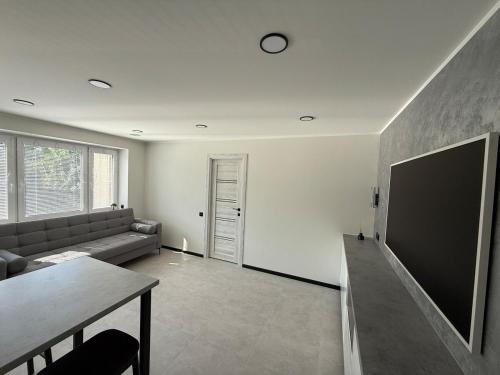 a living room with a couch and a flat screen tv at New modern apartments in the centre in Narva