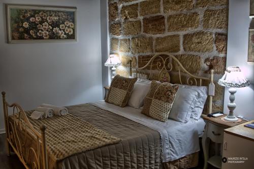 a bedroom with a bed with a stone wall at TAM Vacanze B&B in Cinisi